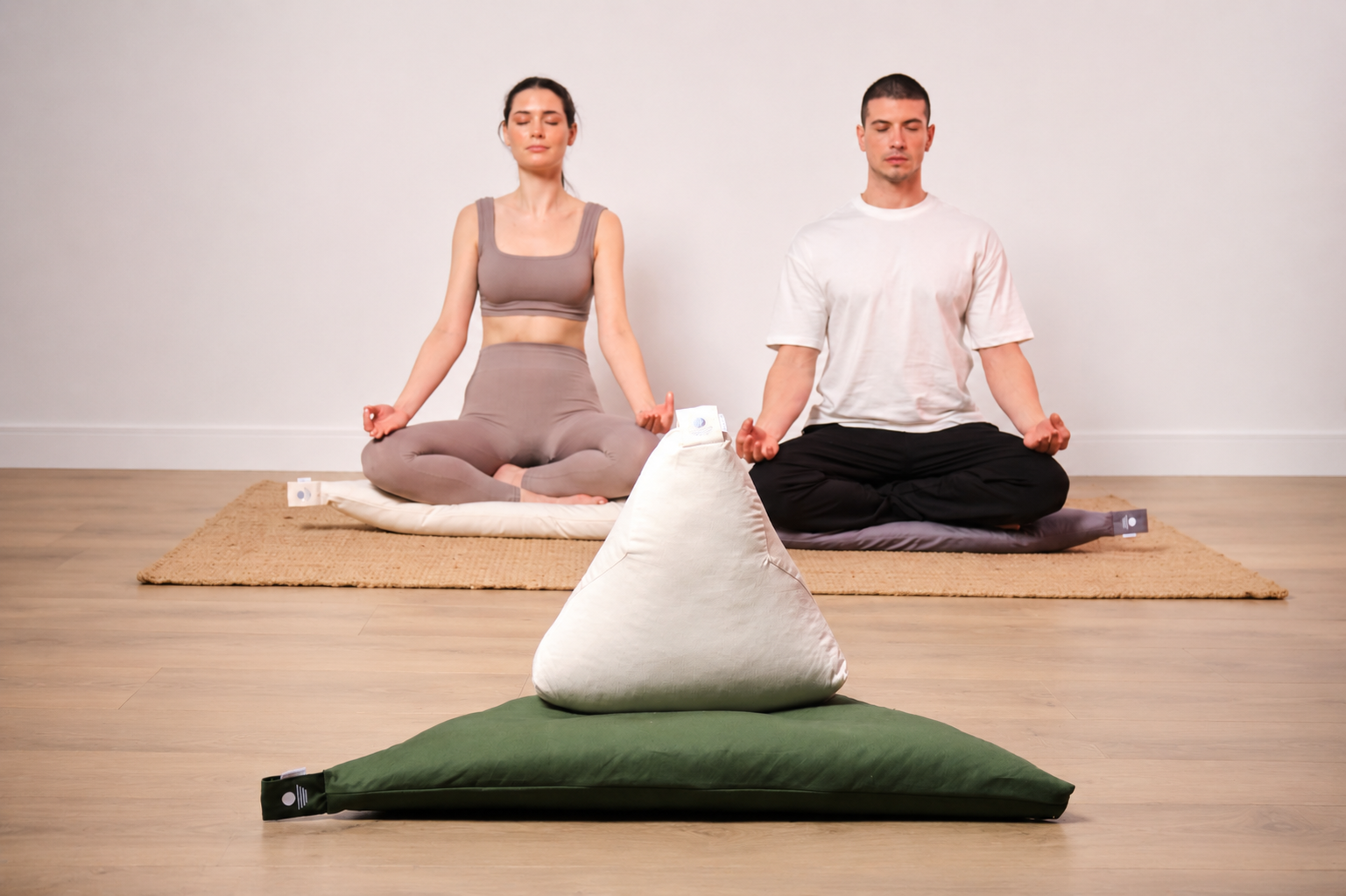 Zwei Personen meditieren auf Dreieck-Yogakissen und Zabuton-Matten – nachhaltiges Meditation Zubehör in mehreren Farben